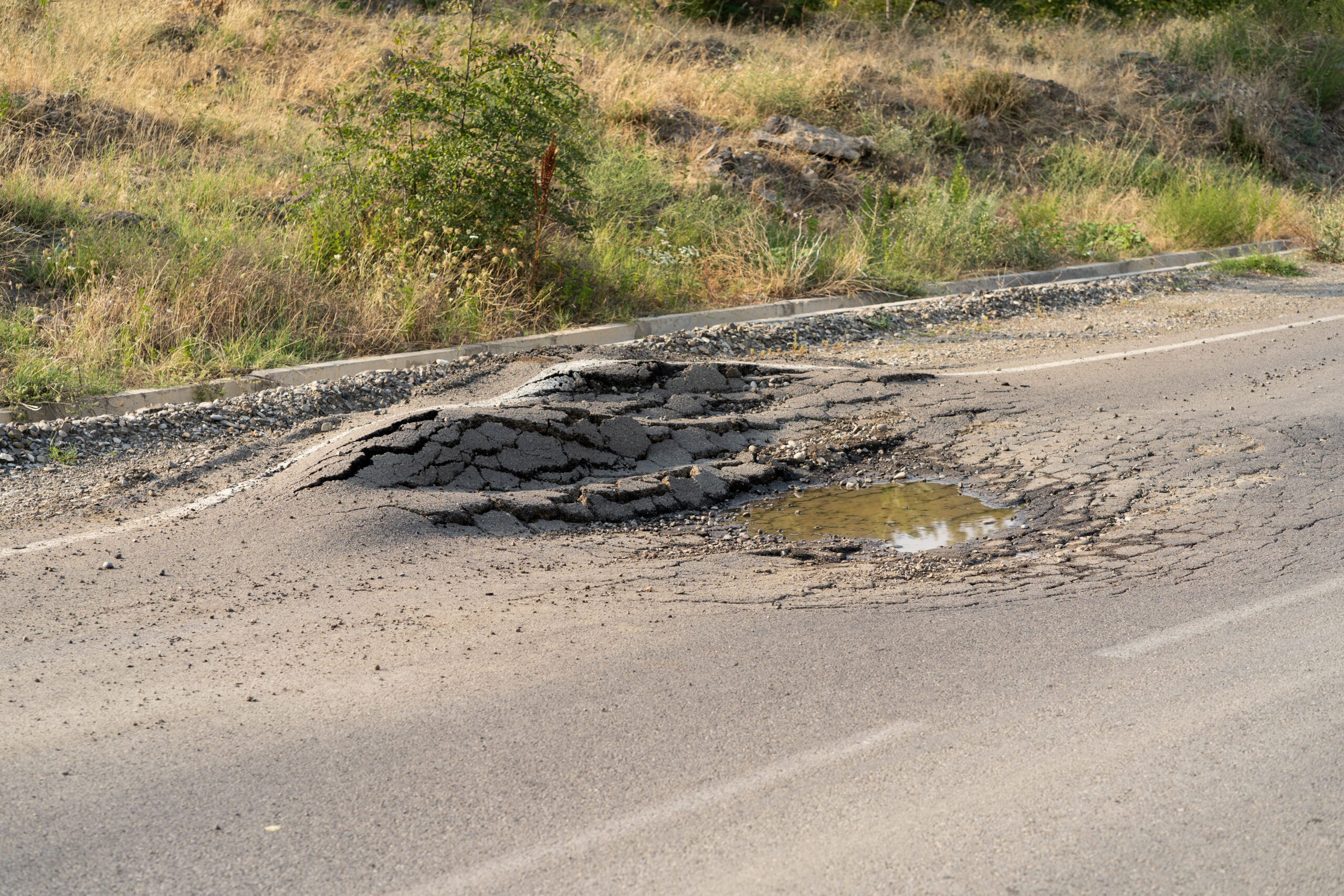 A road crew filling a pothole with fresh asphalt