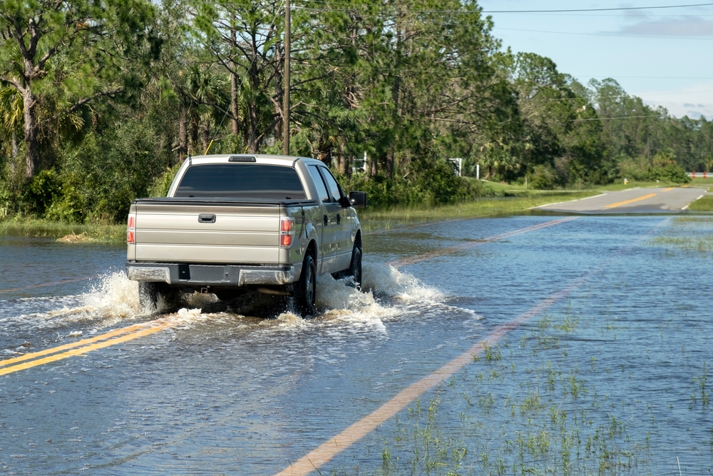 A road with standing water and visible potholes