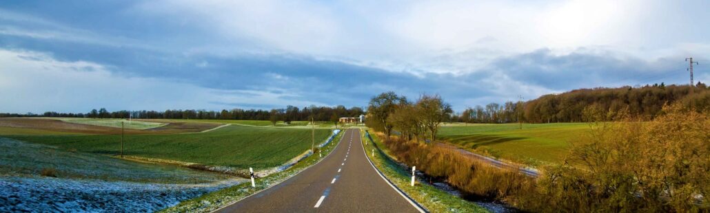 empty-black-asphalt-road-between-green-fields-2025-06-29-06-45-17-utc_11zon