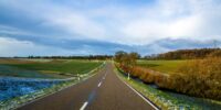 empty-black-asphalt-road-between-green-fields-2025-06-29-06-45-17-utc_11zon
