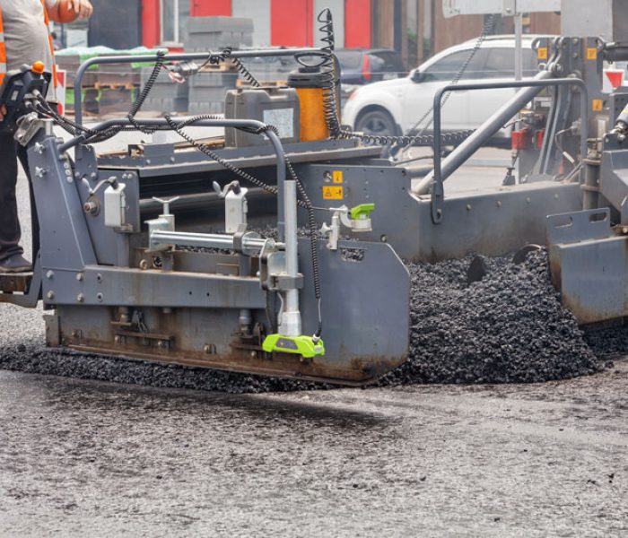 road-worker-in-an-orange-vest-controls-the-paving-2025-02-09-00-31-17-utc