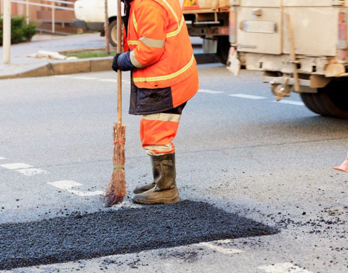 road-worker-levels-a-fresh-asphalt-by-a-wooden-lev-2025-02-08-22-08-29-utc-(1)